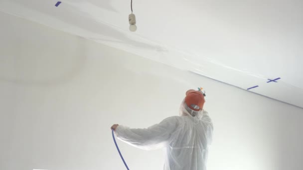 daire onarım - profesyonel ressam beyaz boya sprey tabancası ile duvarları boyar - Video, Çekim