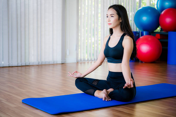 Mujer joven practica yoga en un estudio de gimnasia
. - Foto, imagen