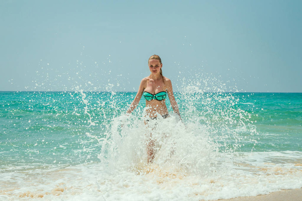 Beautiful young girl coming out of the ocean - Фото, зображення