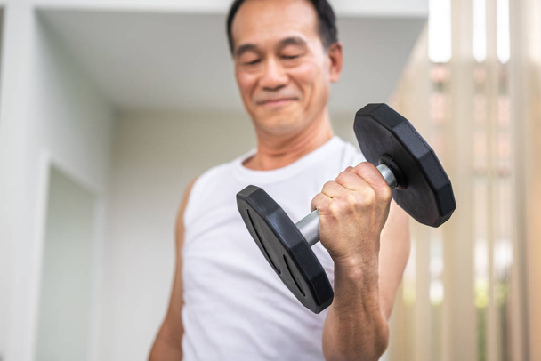 Senior man Lifting halter in fitness gym. - Foto, afbeelding