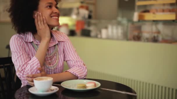 Waitress bringing dessert to beautiful mixed race woman. Pastry shop inetrior. - Filmati, video