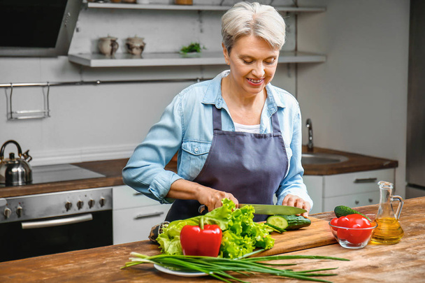 Mature woman cooking in kitchen - Photo, Image