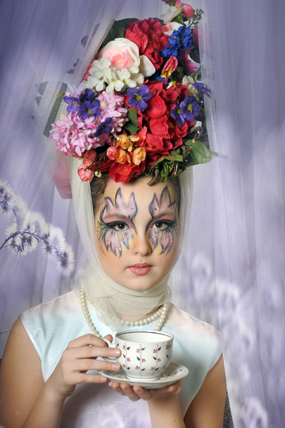 Beautiful girl with flowers on her head during a tea party - Valokuva, kuva