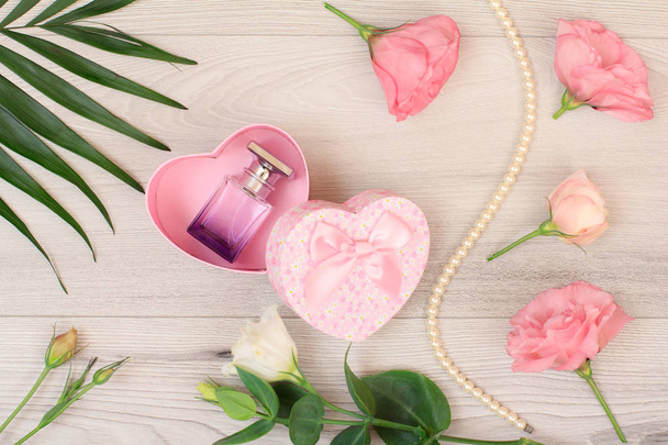 Ahşap tahtaları üzerinde parfüm ve çiçekler şişe ile hediye kutusu - Fotoğraf, Görsel
