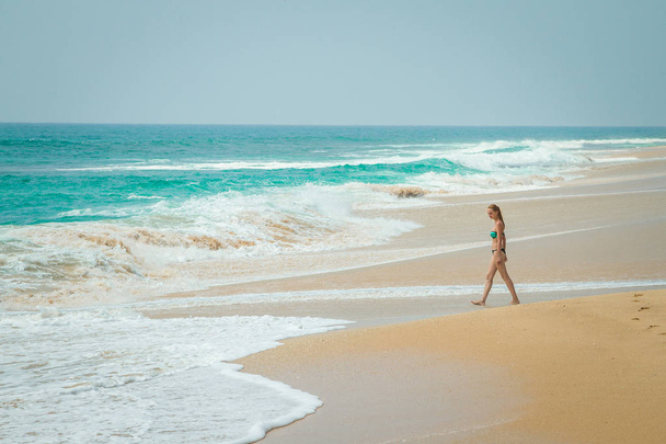 The girl is walking along the beach - Фото, изображение