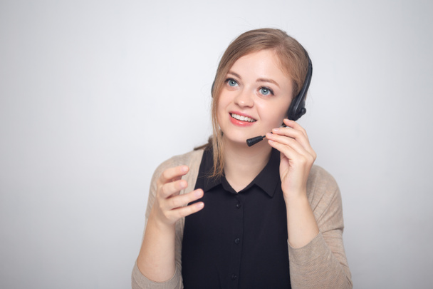 Mujer caucásica joven está hablando en el teléfono auricular en un centro de llamadas
 - Foto, Imagen