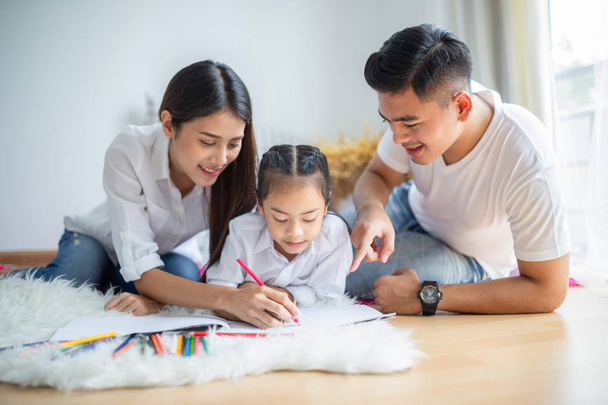 Jonge familie tekening samen met kleurrijke potloden thuis - Foto, afbeelding