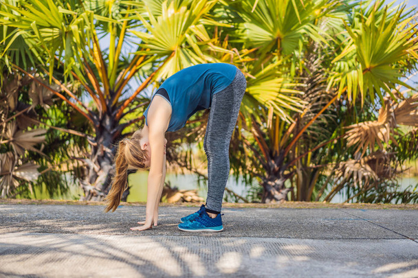 Woman doing yoga in a tropical park - Zdjęcie, obraz