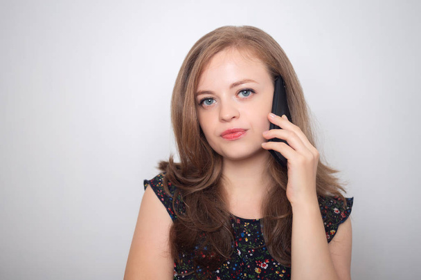 Mulher caucasiana jovem com telefone celular parece irritado, irritado ou mal-humorado
 - Foto, Imagem