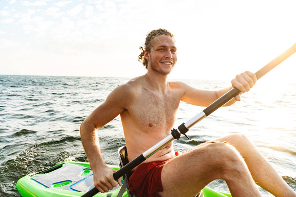 Healthy strong man kayaking - Foto, imagen