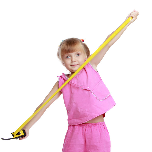Little girl with a building tape measure. - Fotó, kép