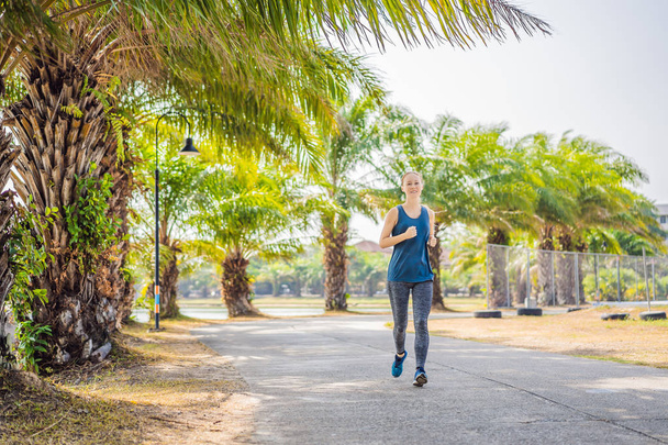 Runner athlete running at tropical park. woman fitness sunrise jogging workout wellness concept - Fotografie, Obrázek