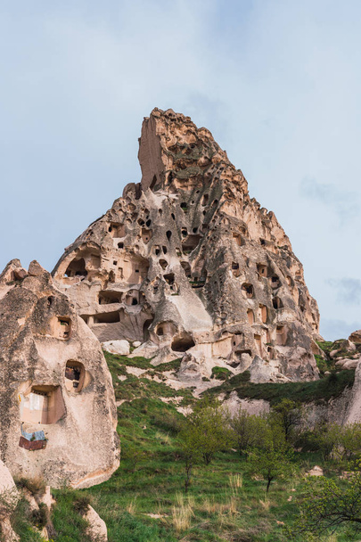 Historical dwellings carved in mountain against sky - Zdjęcie, obraz