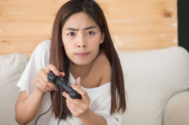 excited woman playing console video game. portrait of excited and fun asian woman plaing vdo game. hobby, liesure activity concept. asian young adult woman model - Photo, image
