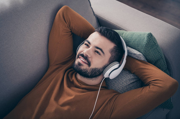 Top above high angle view portrait of handsome lovely student have nap feel content enjoy holiday lie diavn comfy big apartment modern sound track soundtrack orange pullover sweater  - Фото, зображення