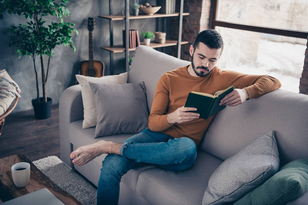 Портрет handosme сосредоточены задумчивый мужчина держать за руку отдыха она сидит диван удобная одежда джинсы пуловер свитер квартира
  - Фото, изображение