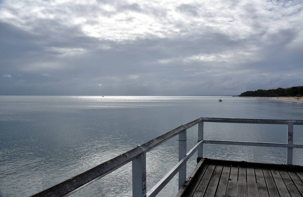 Excelentes vistas de Hervey Bay desde el embarcadero de madera Torquay. muelle es también popular lugar de pesca en todas las mareas. Mar sofocante en día nublado
 - Foto, Imagen