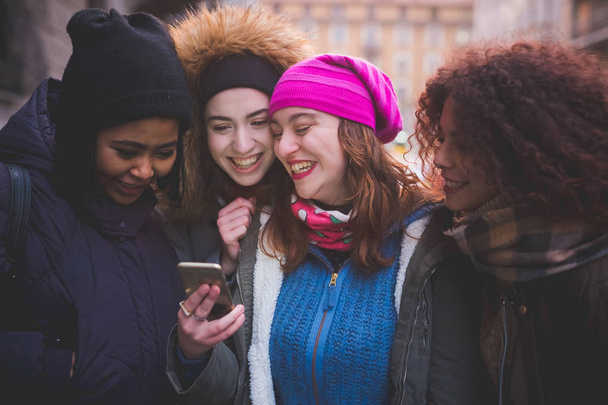 ryhmä nuoria naisia vuorovaikutuksessa älypuhelimen ja hymyilevä
  - Valokuva, kuva