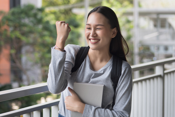 portret szczęśliwy, uśmiechnięty, udany, pewnie Asian Woman student pozowanie wnętrzności stwarzają lub walki, dodać olej, sukces pozować w środowisku miejskim kampusie - Zdjęcie, obraz