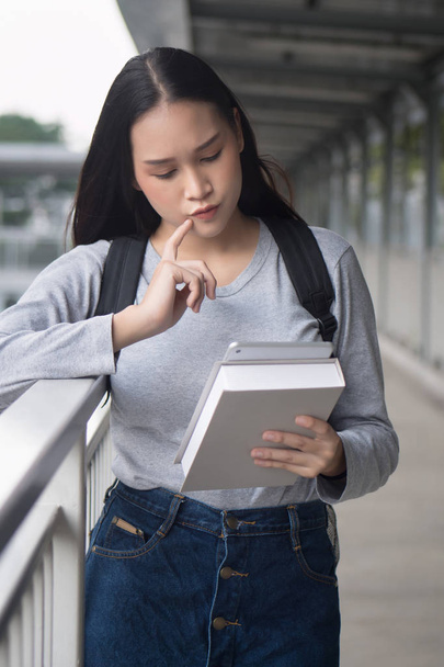несчастная серьезная студентка колледжа, использующая, читающая, смотрящая на планшетный компьютер, онлайн-курс по стилистике образования и концепцию образовательной технологии, супер-модель
 - Фото, изображение