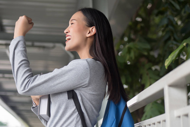 portrait d'une étudiante asiatique heureuse, souriante, réussie et confiante posant des tripes ou se battant, ajoutant de l'huile, posant avec succès dans l'environnement du campus de la ville
 - Photo, image