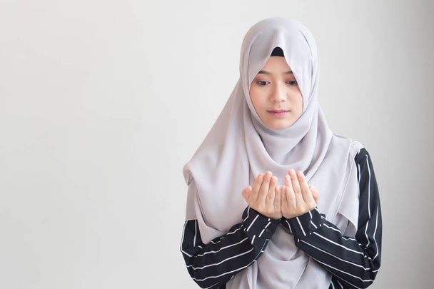молодая современная азиатская мусульманка с исламистской молитвенной рукой; концепция Рамадана, Ид аль Фитр, медитация, исламская молитва, праздник ислама, мусульманская религиозная деятельность
 - Фото, изображение