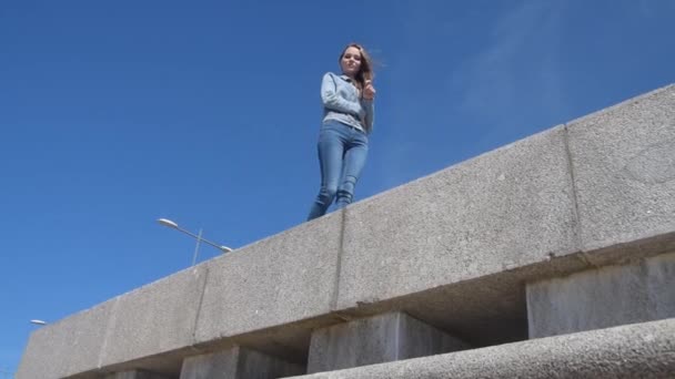 the beautiful tourist girl walking on stone parapet - Кадри, відео
