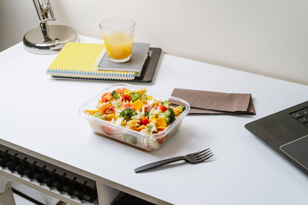 Aliments sains dans la boîte à lunch, sur la table de travail avec ordinateur portable
 - Photo, image