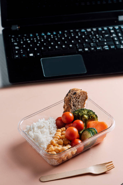 Zdrowe jedzenie w pudełku na lunch, na stole roboczym z laptopem - Zdjęcie, obraz