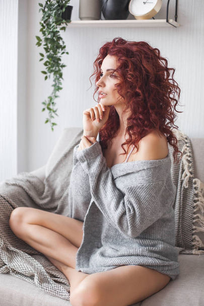 Closeup portrait of young beautiful redhaired woman. Redhead female indoors. Beauty portrait of attractive lady at home with free space. - Photo, Image