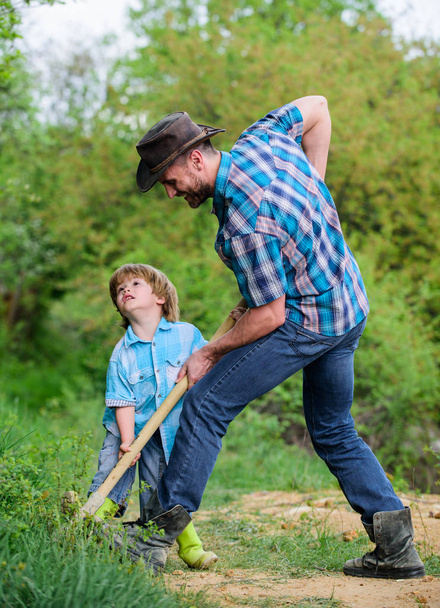 rich natural soil. Eco farm. Ranch. new life. soils and fertilizers. small boy child help father in farming. father and son planting family tree. earth day. Dig grounf with shovel. Helping in garden - Photo, Image
