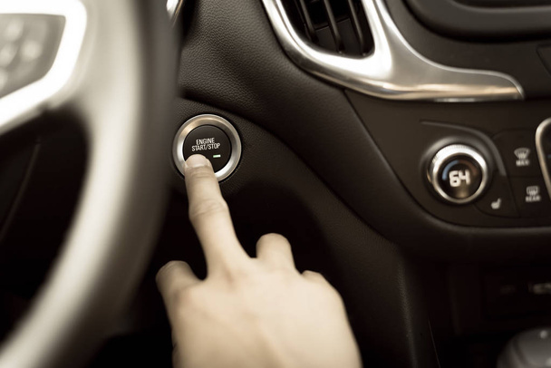 Φιλτραρισμένο χέρι εικόνας πιέζοντας το κουμπί έναρξης διακοπής σε αυτοκίνητο χωρίς κλειδί - Φωτογραφία, εικόνα