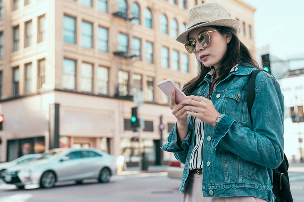 γυναίκα με τα πόδια στο δρόμο και κοιτάζοντας έξυπνο τηλέφωνο  - Φωτογραφία, εικόνα