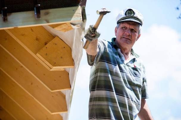 屋根構造の建設現場で働く労働者の屋根葺き職人ビルダー - 写真・画像