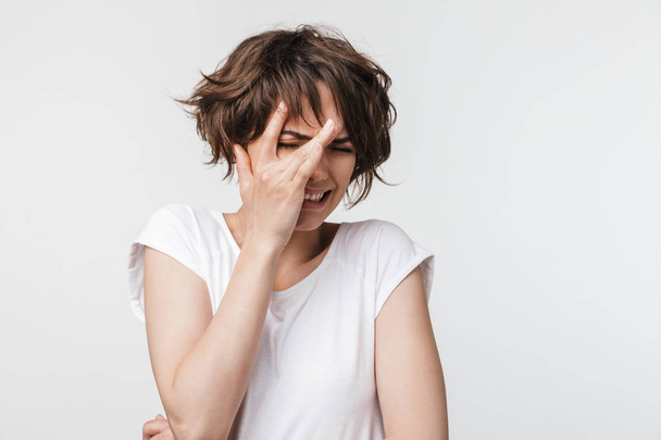 Portrait of scared woman with short brown hair in basic t-shirt  - Foto, Bild