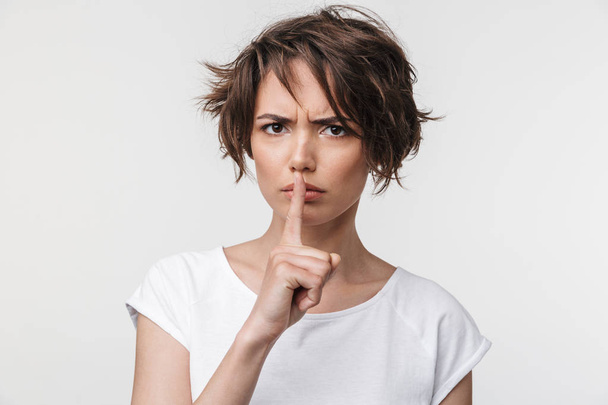 Portrait of angry woman with short brown hair in basic t-shirt h - Foto, afbeelding