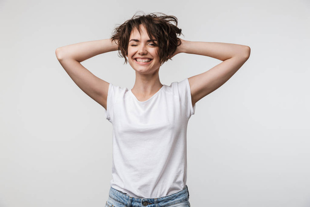 Image of attractive woman in basic t-shirt touching her hair and - Foto, Bild