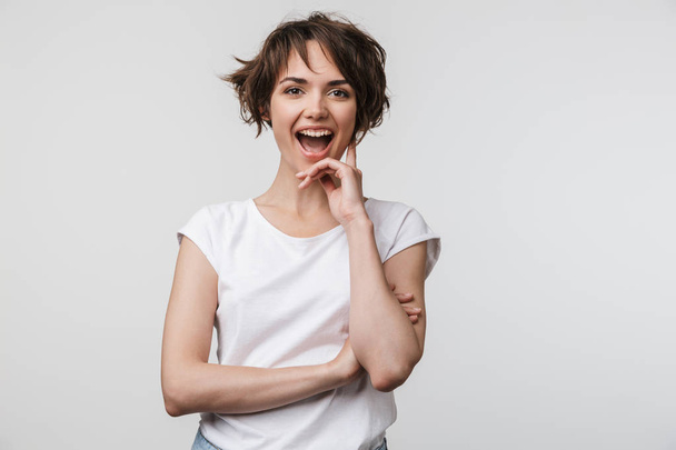 Image of attractive woman in basic t-shirt smiling at camera whi - Foto, immagini