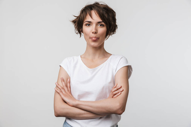 Image of cute woman in basic t-shirt looking at camera while sta - Foto, afbeelding