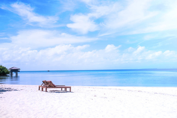 Καρέκλες στην εκπληκτική όμορφη αμμώδη παραλία κοντά στον ωκεανό με γαλάζιο ουρανό. Έννοια του καλοκαιριού αναψυχή ήρεμες διακοπές για μια τουριστική ιδέα. Κενός χώρος αντιγραφής, έμπνευση του τροπικού τοπίου - Φωτογραφία, εικόνα