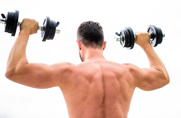 Muscular man exercising with dumbbell rear view. Actions speak louder than coaches. Sportsman with strong back and arms. Sport equipment. Bodybuilding sport. Sport lifestyle. Dumbbell exercise gym - Φωτογραφία, εικόνα