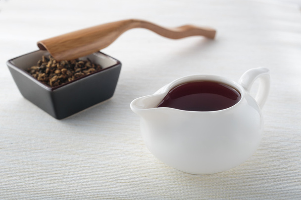 Черный чай и чайные листья с деревянной ложкой
 - Фото, изображение