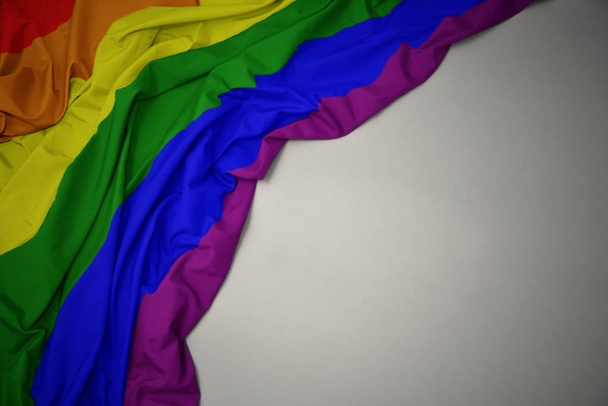waving gay rainbow flag on a gray background. - Photo, Image
