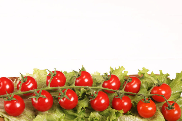 reifen frischen saftigen Bio-Brunch von Kirschtomaten auf Schneidebrett mit grünem Salat auf weißem Tisch. Ansicht von oben - Foto, Bild