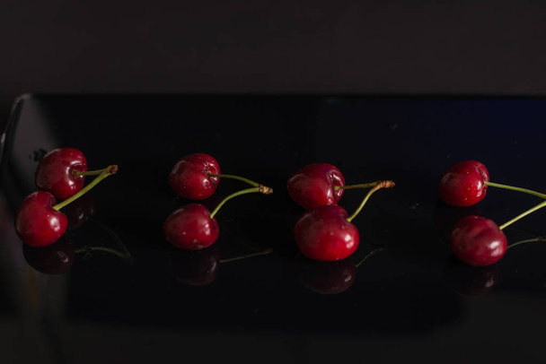  red cherries on black background - Photo, Image