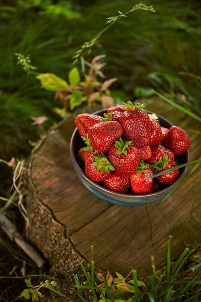 sweet organic strawberries in bowl on stump - Photo, Image