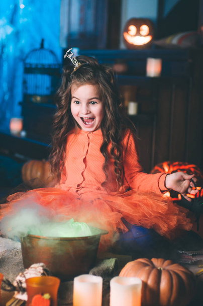Egy kislány boszorkányjelmezben, varázspálcával. - Fotó, kép