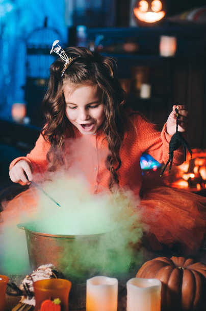 Egy kislány boszorkányjelmezben, varázspálcával. - Fotó, kép