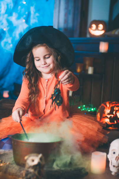 Little girl in a costume of witch with magic wand and spider - Photo, Image