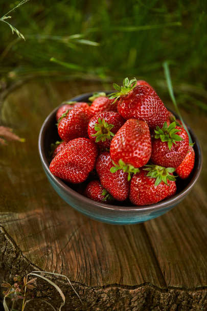 fresh delicious strawberries in bowl on stump - Foto, afbeelding